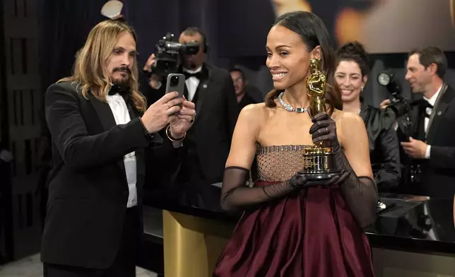 Marco Perego-Saldana, left, and Zoe Saldana, winner of the award for best performance by an actress in a supporting role for "Emilia Perez," attend the Governors Ball after the Oscars on Sunday, March 2, 2025, in Los Angeles. (AP Photo/John Locher)