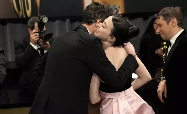 Alex Coco, left, winner of the award for best picture for "Anora," and Mikey Madison, winner of the award for best performance by an actress in a leading role for "Anora," embrace at the Governors Ball after the Oscars on Sunday, March 2, 2025, in Los Angeles. (AP Photo/John Locher)