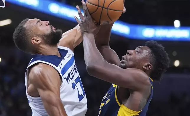 Indiana Pacers center Thomas Bryant (3) shoots over Minnesota Timberwolves center Rudy Gobert (27) during the first half of an NBA basketball game in Indianapolis, Monday, March 24, 2025. (AP Photo/Michael Conroy)