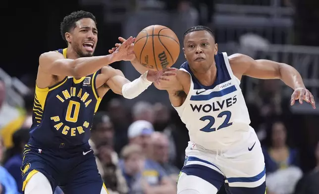 Minnesota Timberwolves guard Jaylen Clark (22) steals the ball from Indiana Pacers guard Tyrese Haliburton (0) during the second half of an NBA basketball game in Indianapolis, Monday, March 24, 2025. (AP Photo/Michael Conroy)