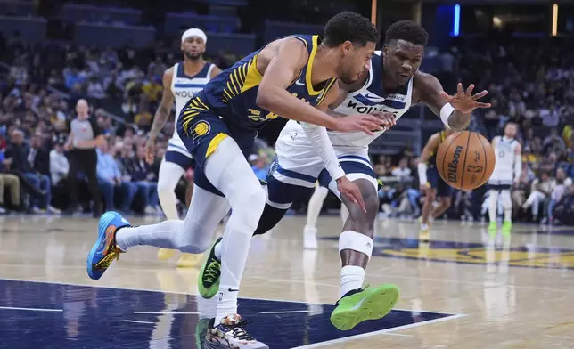 Indiana Pacers guard Tyrese Haliburton (0) and Minnesota Timberwolves guard Anthony Edwards (5) go for a loose ball during the first half of an NBA basketball game in Indianapolis, Monday, March 24, 2025. (AP Photo/Michael Conroy)