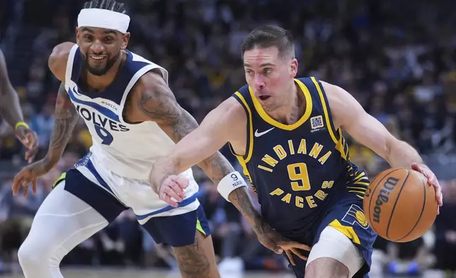Indiana Pacers guard T.J. McConnell (9) drives on Minnesota Timberwolves guard Nickeil Alexander-Walker (9) during the first half of an NBA basketball game in Indianapolis, Monday, March 24, 2025. (AP Photo/Michael Conroy)