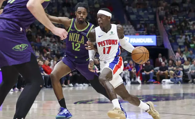 Detroit Pistons guard Dennis Schroeder (17) tries to drive past New Orleans Pelicans guard Antonio Reeves (12) in the second half of an NBA basketball game in New Orleans, Monday, March 17, 2025. (AP Photo/Peter Forest)