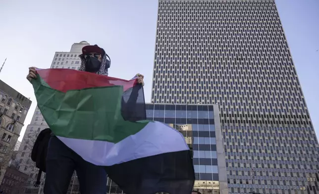 A protester holds Palestinian flag in front of Federal Plaza during a demonstration in support of Palestinian activist Mahmoud Khalil, Monday, March 10, 2025, in New York. (AP Photo/Yuki Iwamura)