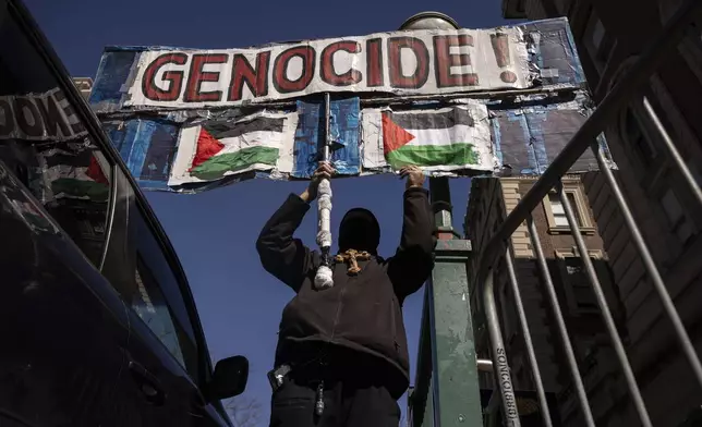 A protester raises a sign during their demonstration in support of Palestinian activist Mahmoud Khalil outside Columbia University, Monday, March 10, 2025, in New York. (AP Photo/Yuki Iwamura)