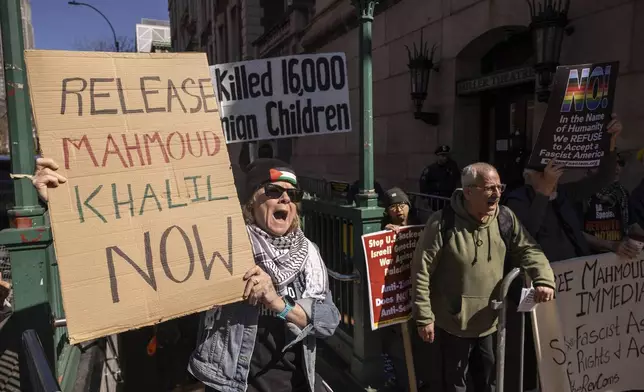 A protester raises signs during a demonstration in support of Palestinian activist Mahmoud Khalil outside Columbia University, Monday, March 10, 2025, in New York. (AP Photo/Yuki Iwamura)