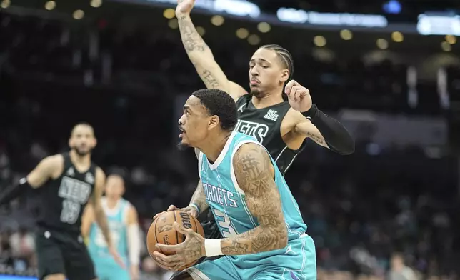 Charlotte Hornets guard DaQuan Jeffries (3) is defended by Brooklyn Nets forward Jalen Wilson, right, during the first half of an NBA basketball game, Saturday, March 8, 2025, in Charlotte, N.C. (AP Photo/Matt Kelley)