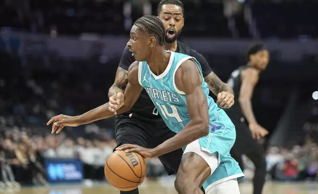 Charlotte Hornets forward Moussa Diabate (14) is defended by Brooklyn Nets guard D'Angelo Russell, back, during the first half of an NBA basketball game, Saturday, March 8, 2025, in Charlotte, N.C. (AP Photo/Matt Kelley)