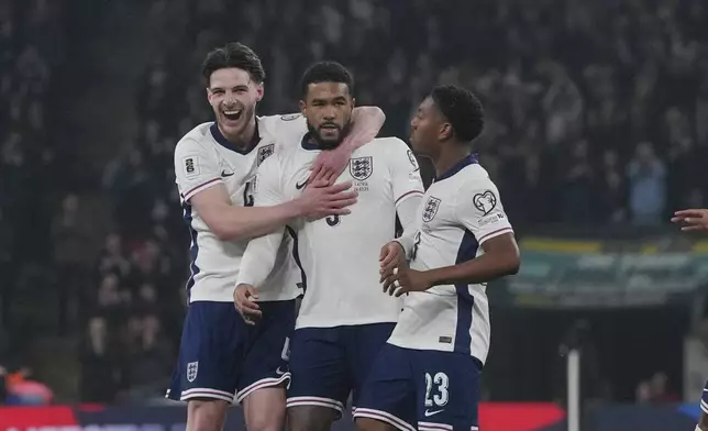 England's Reece James, centre, celebrates with teammates after scoring his side's opening goal during a World Cup qualifying soccer match between England and Latvia at Wembley stadium in London, Monday, March 24, 2025. (AP Photo/Kin Cheung)