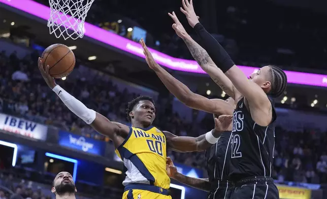 Indiana Pacers guard Bennedict Mathurin (00) makes a pass around Brooklyn Nets forward Jalen Wilson (22) during the second half of an NBA basketball game in Indianapolis, Thursday, March 20, 2025. (AP Photo/Michael Conroy)