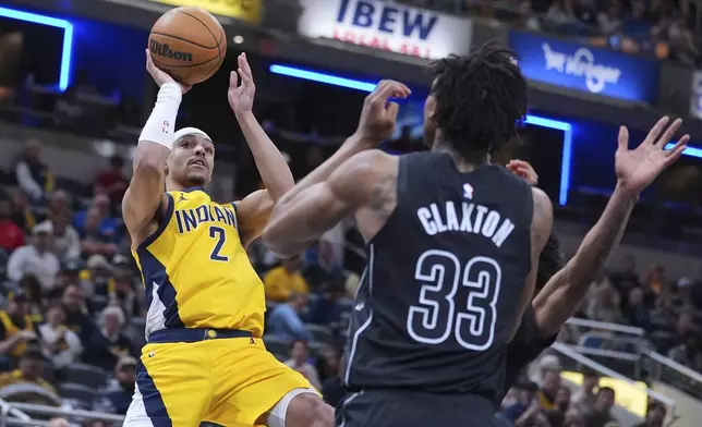Indiana Pacers guard Andrew Nembhard (2) shoots over Brooklyn Nets center Nic Claxton (33) during the second half of an NBA basketball game in Indianapolis, Thursday, March 20, 2025. (AP Photo/Michael Conroy)
