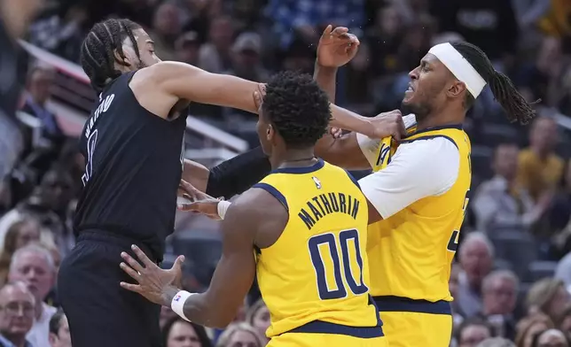 Brooklyn Nets forward Trendon Watford, left, Indiana Pacers center Myles Turner (33) and guard Bennedict Mathurin (00) scuffle during the second half of an NBA basketball game in Indianapolis, Thursday, March 20, 2025. (AP Photo/Michael Conroy)