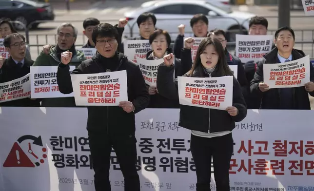 Protesters shout slogans during a press conference demanding to stop the upcoming Freedom Shield military exercise between the U.S. and South Korea and also demanding to investigate the cause thoroughly about fighter jets accidentally dropped eight bombs on a civilian area, in Seoul, South Korea, Friday, March 7, 2025. Banners read "Stop the Freedom Shield military exercise between the U.S. and South Korea." (AP Photo/Lee Jin-man)