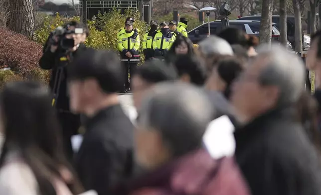 Police officers stand guard as protesters attend a press conference demanding to stop the upcoming Freedom Shield military exercise between the U.S. and South Korea and also demanding to investigate the cause thoroughly about fighter jets accidentally dropped eight bombs on a civilian area, in Seoul, South Korea, Friday, March 7, 2025. (AP Photo/Lee Jin-man)