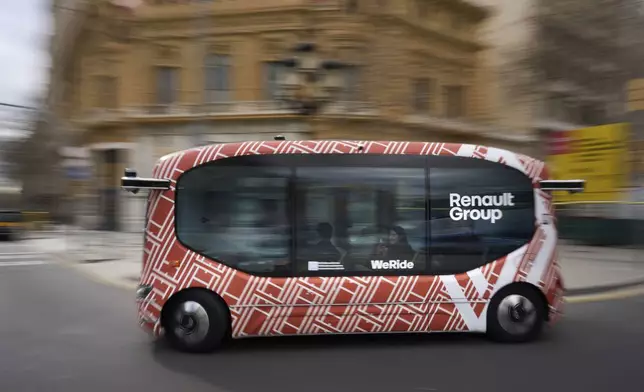 A driverless mini-bus, presented by WeRide and Renault Group, drives along a street in Barcelona downtown, Wednesday, March 12, 2025. (AP Photo/Emilio Morenatti)
