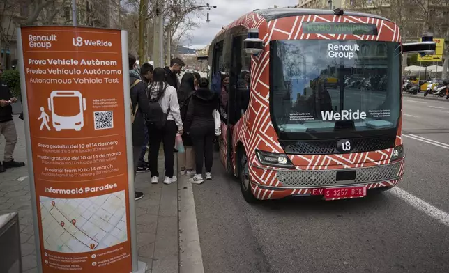 Passengers board a driverless mini-bus, presented by WeRide and Renault Group, in Barcelona downtown, Wednesday, March 12, 2025. (AP Photo/Emilio Morenatti)