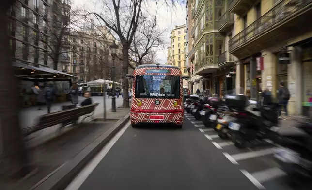A driverless mini-bus, presented by WeRide and Renault Group, drives along a street in Barcelona downtown, Wednesday, March 12, 2025. Commuters in downtown Barcelona have been able to ride the bus for free this week. There's just one catch: this mini-bus has no one at the wheel. (AP Photo/Emilio Morenatti)