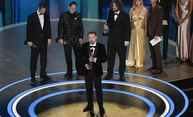 Gregory Zalcman, from left, Ron Dyens, Gints Zilbalodis, center, and Matiss Kaza accept the award for best animated feature film for "Flow" during the Oscars on Sunday, March 2, 2025, at the Dolby Theatre in Los Angeles. Goldie Hawn, second right, and Andrew Garfield look on from right. (AP Photo/Chris Pizzello)