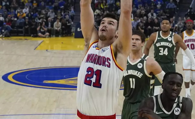 Golden State Warriors center Quinten Post (21) dunks next to Milwaukee Bucks forward Taurean Prince (12) during the first half of an NBA basketball game Tuesday, March 18, 2025, in San Francisco. (AP Photo/Godofredo A. Vásquez)