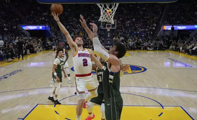 Golden State Warriors guard Brandin Podziemski (2) shoots while defended by Milwaukee Bucks center Brook Lopez, right, during the first half of an NBA basketball game Tuesday, March 18, 2025, in San Francisco. (AP Photo/Godofredo A. Vásquez)