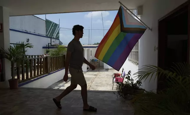 A person walks past a pride flag at Casa Frida, a shelter that supports LGBTQ+ migrants, in Tapachula, Chiapas state, Mexico, Wednesday, March 12, 2025. (AP Photo/Moises Castillo)