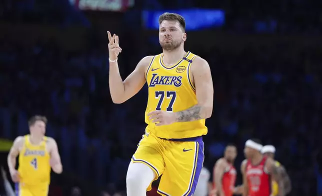 Los Angeles Lakers' Luka Doncic (77) celebrates his three-point basket during the first half of an NBA basketball game against the New Orleans Pelicans Tuesday, March 4, 2025, in Los Angeles. (AP Photo/Jae C. Hong)