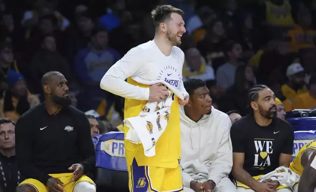 Los Angeles Lakers' Luka Doncic smiles as he puts on a shirt during the second half of an NBA basketball game against the New Orleans Pelicans Tuesday, March 4, 2025, in Los Angeles. (AP Photo/Jae C. Hong)