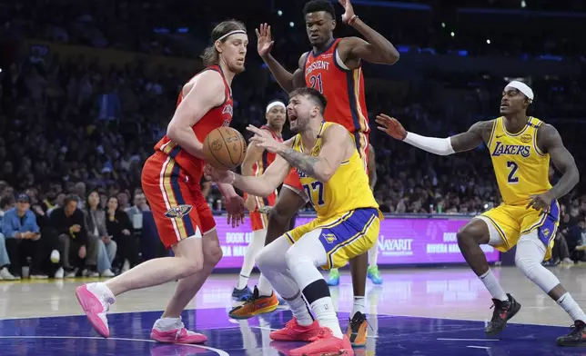 Los Angeles Lakers' Luka Doncic (77) is fouled by New Orleans Pelicans' Kelly Olynyk (13) during the second half of an NBA basketball game Tuesday, March 4, 2025, in Los Angeles. (AP Photo/Jae C. Hong)