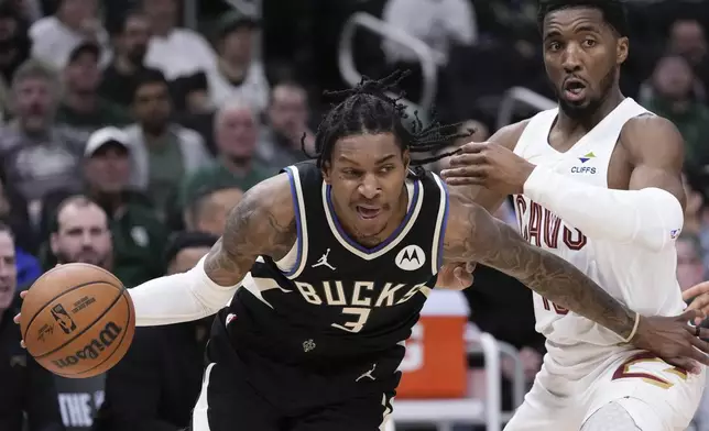 Milwaukee Bucks' Kevin Porter Jr. gets by Cleveland Cavaliers' Donovan Mitchell during the first half of an NBA basketball game Sunday, Mar. 9, 2025, in Milwaukee. (AP Photo/Morry Gash)