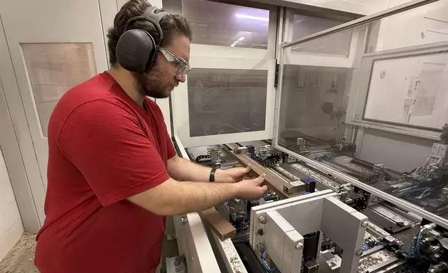 Built by Newport furniture company employee Nathan Martin machines parts for hardwood furniture after the business's owner, Dave Laforce, who sources material from Canada, attended a roundtable event with U.S. Sen. Peter Welch of Vermont and Marie-Claude Bibeau, a Canadian member of parliament, to discuss the Trump administration's tariffs, Tuesday, March 18, 2025, in Newport, Vt. (AP Photo/Amanda Swinhart)