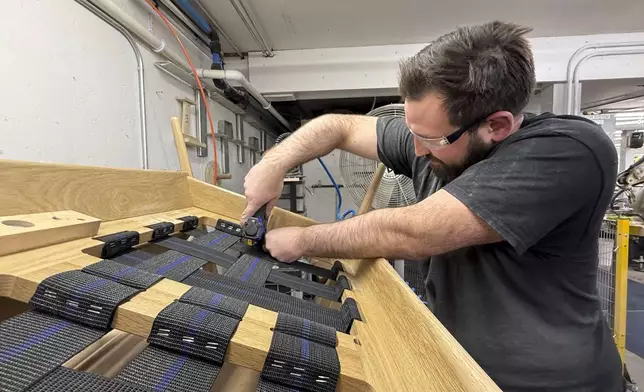 Built by Newport furniture company employee Eric Benware puts webbing on a sofa after the business's owner Dave Laforce, who sources material from Canada, attended a roundtable event with U.S. Sen. Peter Welch of Vermont and Marie-Claude Bibeau, a Canadian member of parliament, to discuss the Trump administration's tariffs, Tuesday, March 18, 2025, in Newport, Vt. (AP Photo/Amanda Swinhart)