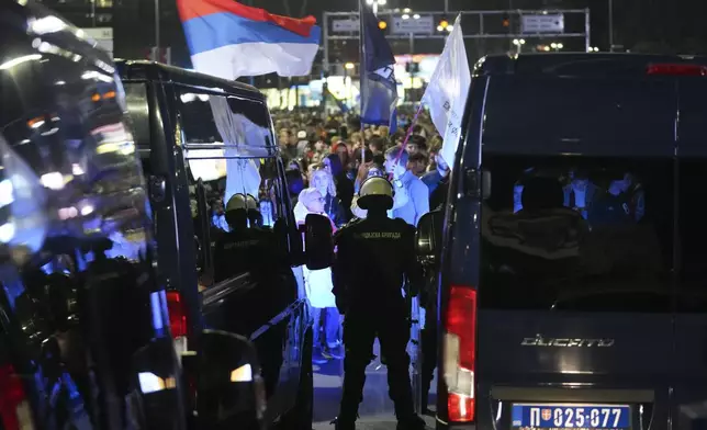 Serbian police officers block a bridge as students and citizens march to protest the deaths of 15 people killed in the November collapse of a train station canopy in Belgrade, Serbia, Saturday, March 8, 2025. (AP Photo/Darko Vojinovic)