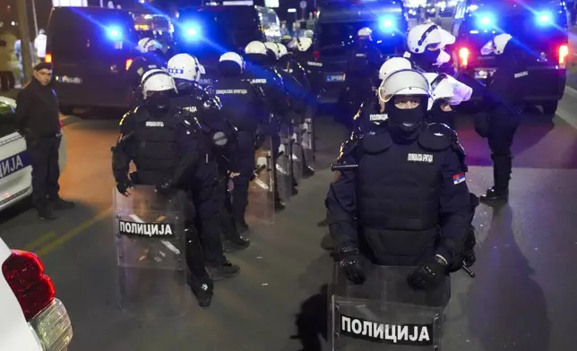 Serbian police officers block a bridge when students and citizens march to protest the deaths of 15 people killed in the November collapse of a train station canopy in Belgrade, Serbia, Saturday, March 8, 2025. (AP Photo/Darko Vojinovic)