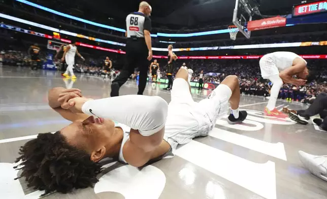 Dallas Mavericks forward Kessler Edwards, left, and center Dwight Powell react after colliding while chasing a rebound against the Phoenix Suns during the second half of an NBA basketball game Sunday, March 9, 2025, in Dallas. (AP Photo/Julio Cortez)