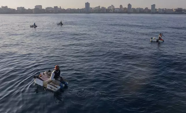 People fish on makeshift rafts in Havana, Wednesday, March 19, 2025. (AP Photo/Ramon Espinosa)