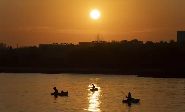 People fish on makeshift rafts at dawn in Cojimar, east of Havana, Tuesday, March 25, 2025. (AP Photo/Ramon Espinosa)