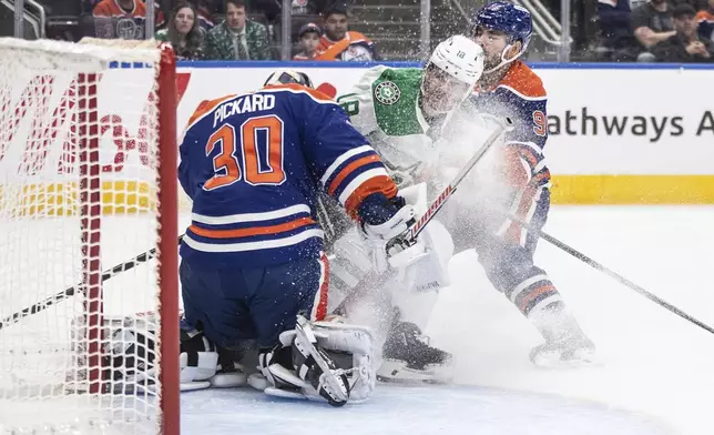Dallas Stars' Sam Steel (18) and Edmonton Oilers' Jake Walman (96) crash into goalie Calvin Pickard (30) during the third period of an NHL game in Edmonton on Wednesday, March 26, 2025. (Jason Franson/The Canadian Press via AP)