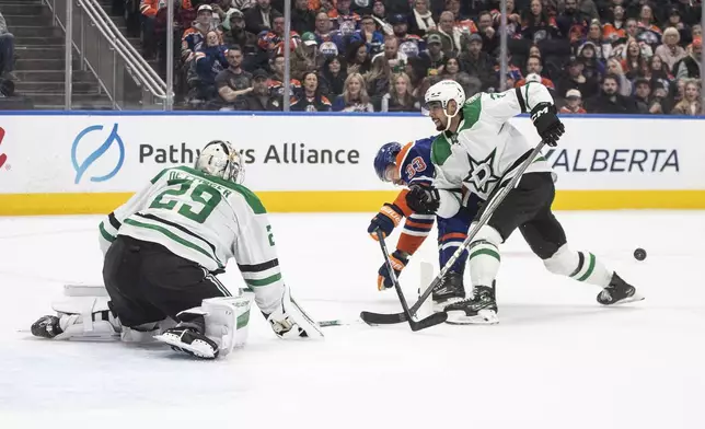 Dallas Stars goalie Jake Oettinger (29) looks for the puck as Matt Dumba (3) knocks the puck away from Edmonton Oilers' Viktor Arvidsson (33) during the second period of an NHL game in Edmonton on Wednesday, March 26, 2025. (Jason Franson/The Canadian Press via AP)
