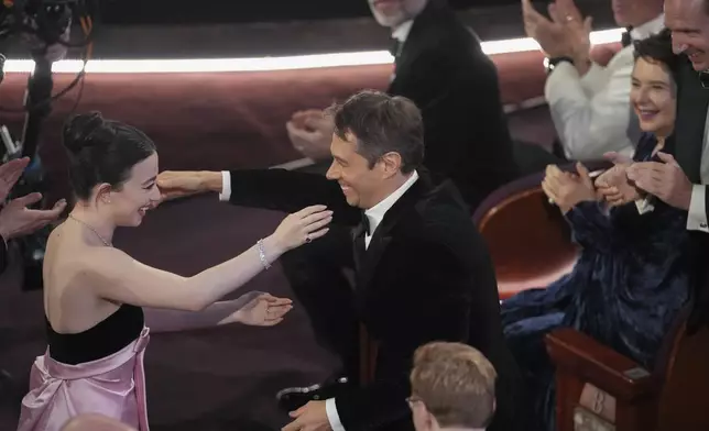 Mikey Madison, left, embraces Sean Baker after he wins the award for best original screenplay for "Anora" during the Oscars on Sunday, March 2, 2025, at the Dolby Theatre in Los Angeles. (AP Photo/Chris Pizzello)