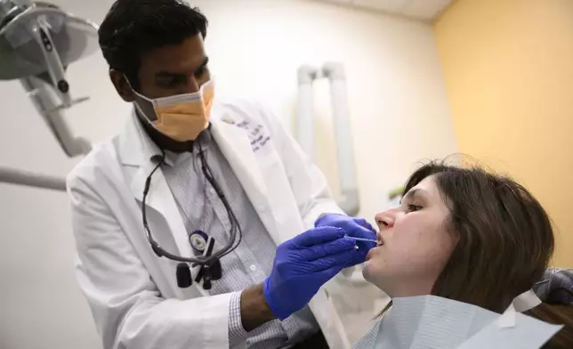 Alexander Daniel, DDS, left, demonstrates fluoride treatment on resident Cameron Onken, right, at the Johns Hopkins Outpatient Center, Friday, Feb. 28, 2025, in Baltimore. (AP Photo/Nick Wass)