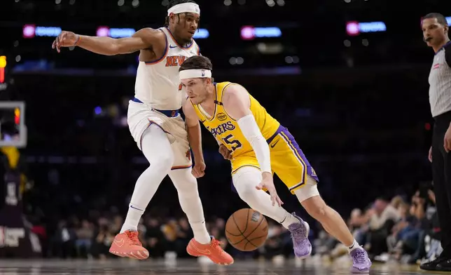 Los Angeles Lakers guard Austin Reaves, right, drives past New York Knicks guard Miles McBride during the first half of an NBA basketball game Thursday, March 6, 2025, in Los Angeles. (AP Photo/Mark J. Terrill)