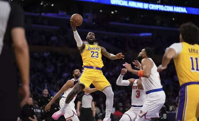 Los Angeles Lakers forward LeBron James (23) shoots as New York Knicks center Karl-Anthony Towns (32) and guard Josh Hart (3) defends while center Jaxson Hayes (11) watches during the first half of an NBA basketball game Thursday, March 6, 2025, in Los Angeles. (AP Photo/Mark J. Terrill)