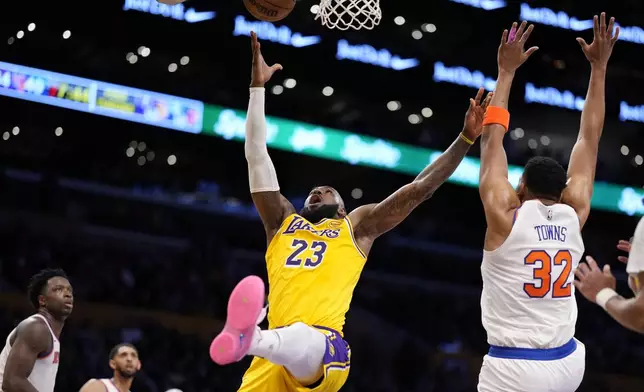 Los Angeles Lakers forward LeBron James (23) shoots as New York Knicks center Karl-Anthony Towns (32) defends during the first half of an NBA basketball game Thursday, March 6, 2025, in Los Angeles. (AP Photo/Mark J. Terrill)