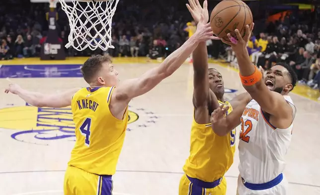 New York Knicks center Karl-Anthony Towns, right, shoots as Los Angeles Lakers guard Dalton Knecht, left, and center Trey Jemison III defend during the first half of an NBA basketball game Thursday, March 6, 2025, in Los Angeles. (AP Photo/Mark J. Terrill)