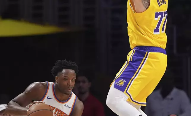 New York Knicks forward OG Anunoby, left, tires to pass as Los Angeles Lakers guard Luka Doncic defends during the first half of an NBA basketball game Thursday, March 6, 2025, in Los Angeles. (AP Photo/Mark J. Terrill)