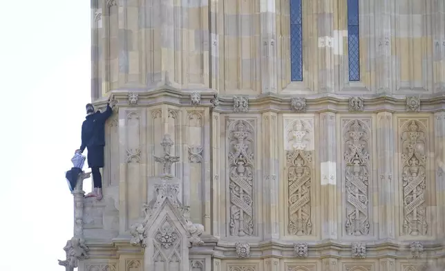 A view of a man with a Palestine flag after he climbed up Elizabeth Tower, which houses Big Ben, at the Palace of Westminster, in London, Saturday, March 8, 2025. (James Manning/PA via AP)