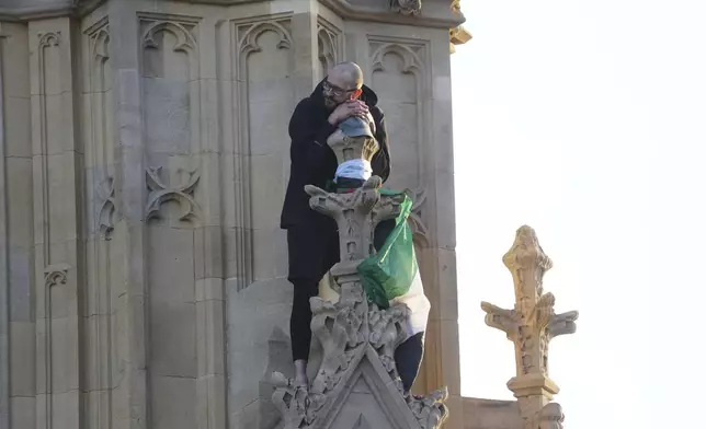 A man with a Palestinian flag after he climbed up Elizabeth Tower, at the Palace of Westminster in London, Saturday, March 8, 2025. (Jeff Moore/PA via AP)
