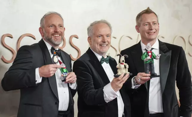 Richard Beek, from left, Nick Park and Merlin Crossingham arrive at the Oscars on Sunday, March 2, 2025, at the Dolby Theatre in Los Angeles. (AP Photo/Jae C. Hong)