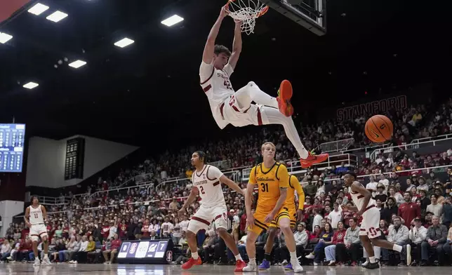 California forward Rytis Petraitis (31) watches as Stanford forward Maxime Raynaud (42) dunks during the first half of an NCAA college basketball game Saturday, Feb. 22, 2025, in Stanford, Calif. (AP Photo/Godofredo A. Vásquez)