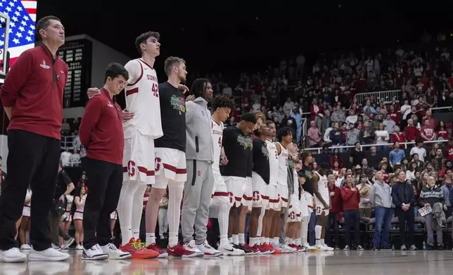 Stanford forward Maxime Raynaud (42) and teammates listen to the national anthem before an NCAA college basketball game against California, Saturday, Feb. 22, 2025, in Stanford, Calif. (AP Photo/Godofredo A. Vásquez)